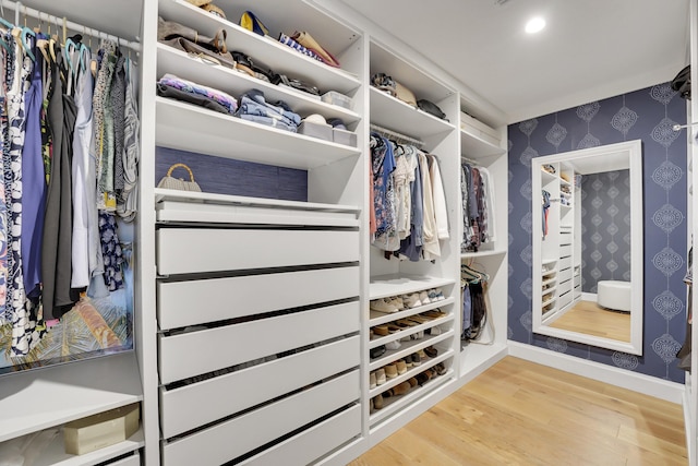 walk in closet with light hardwood / wood-style flooring