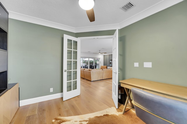 office featuring french doors, ceiling fan, ornamental molding, and light hardwood / wood-style flooring