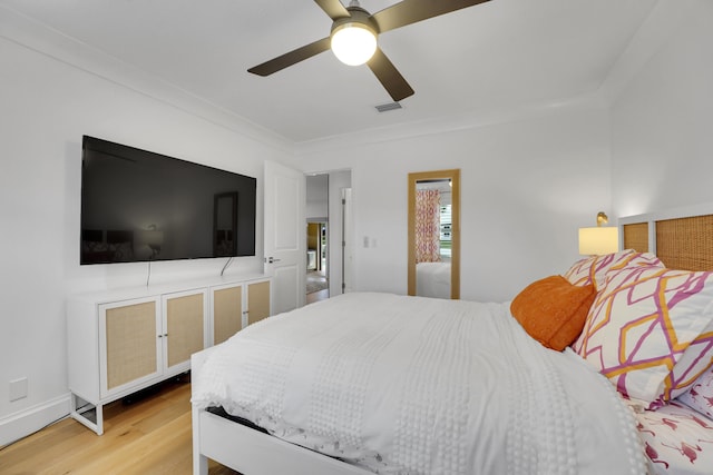 bedroom featuring ceiling fan, ornamental molding, and wood-type flooring