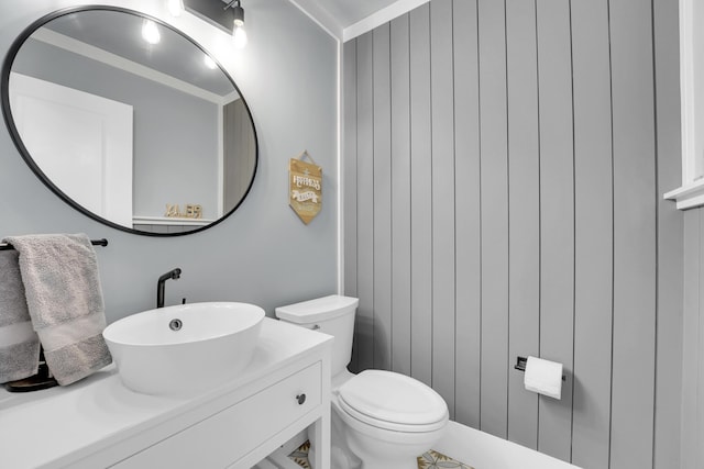 bathroom with vanity, crown molding, and toilet