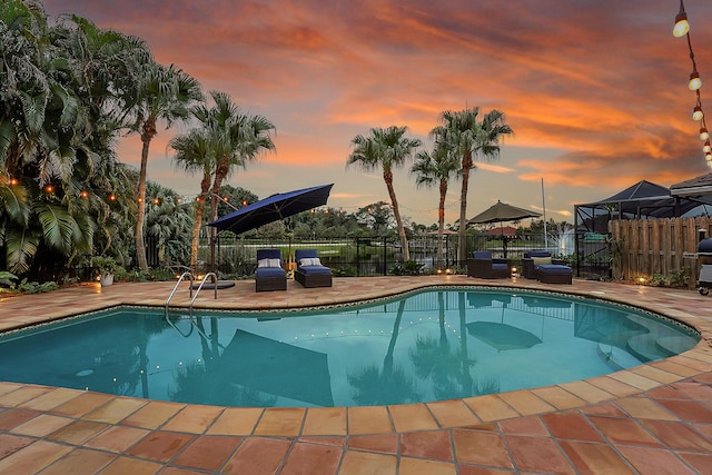 pool at dusk with a patio area