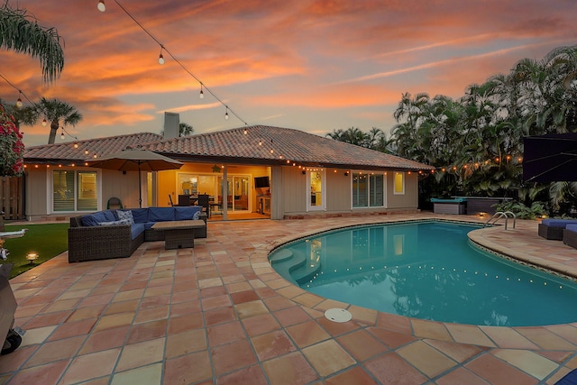 pool at dusk with an outdoor hangout area and a patio