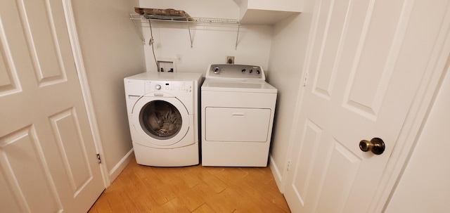 washroom with light hardwood / wood-style floors and separate washer and dryer