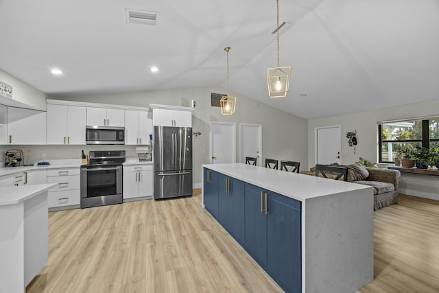 kitchen with pendant lighting, appliances with stainless steel finishes, white cabinets, blue cabinets, and a kitchen island