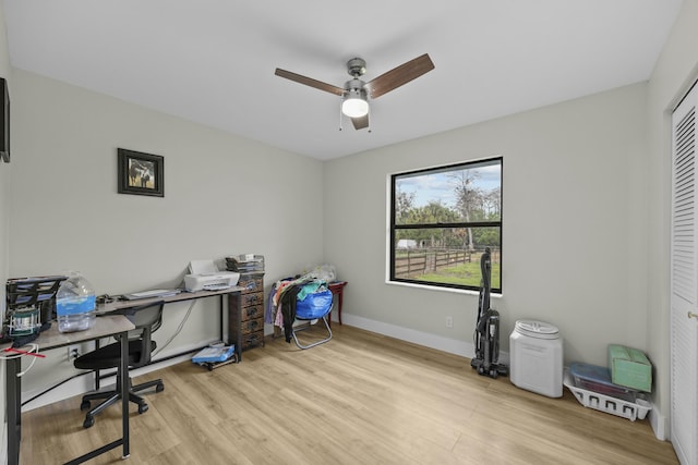 office with light hardwood / wood-style floors and ceiling fan