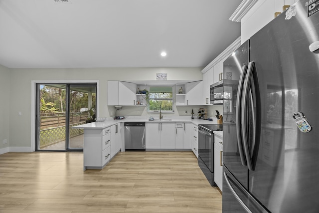 kitchen with white cabinets, stainless steel appliances, and a healthy amount of sunlight