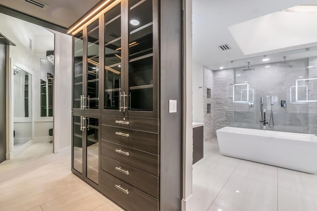 bathroom featuring tile patterned flooring and separate shower and tub