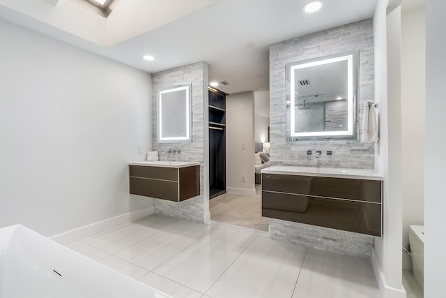 bathroom with tile patterned floors, vanity, and a skylight