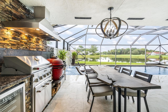 view of patio / terrace featuring an outdoor kitchen, a grill, pool water feature, a lanai, and a water view