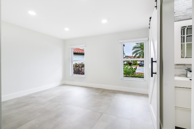 empty room featuring a barn door and a wealth of natural light