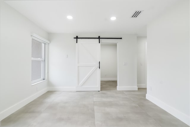 unfurnished room featuring a barn door