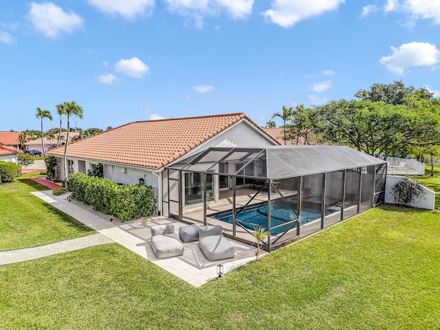 rear view of property featuring a patio area, glass enclosure, and a lawn