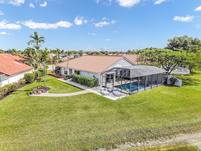 rear view of property featuring a patio area, glass enclosure, and a lawn