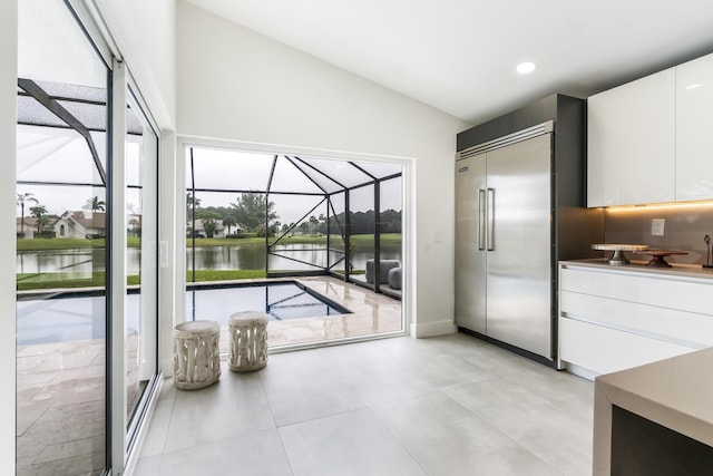 doorway with a water view and lofted ceiling