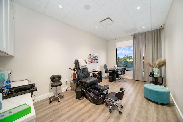 interior space featuring a paneled ceiling and light hardwood / wood-style flooring