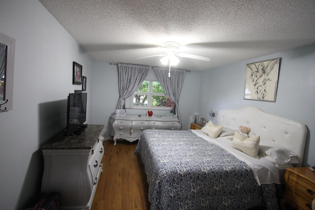 bedroom featuring ceiling fan, dark wood-type flooring, and a textured ceiling