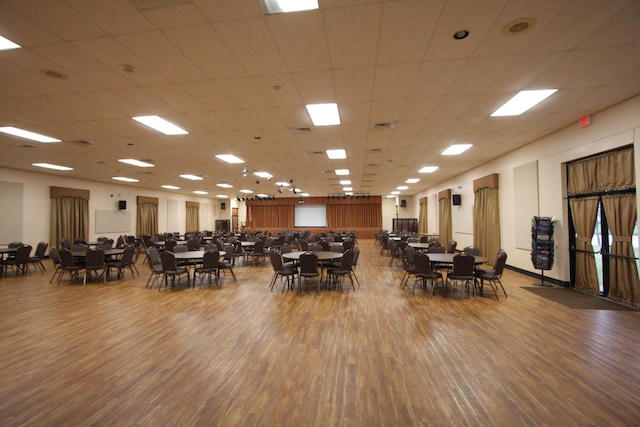 dining area with wood-type flooring and a drop ceiling