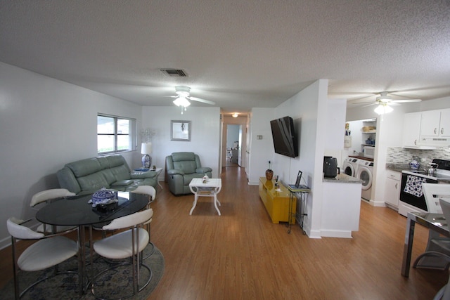 living room featuring ceiling fan, light hardwood / wood-style flooring, and independent washer and dryer