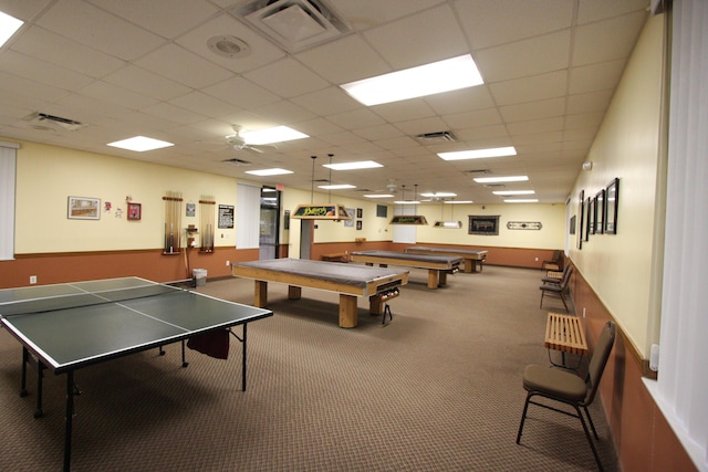 recreation room with carpet floors and a drop ceiling