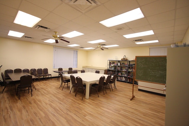 dining room featuring ceiling fan, light hardwood / wood-style flooring, and a drop ceiling