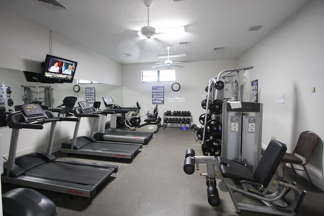 exercise room with ceiling fan and a textured ceiling