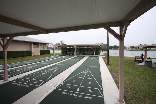 view of property's community featuring a lawn and a water view