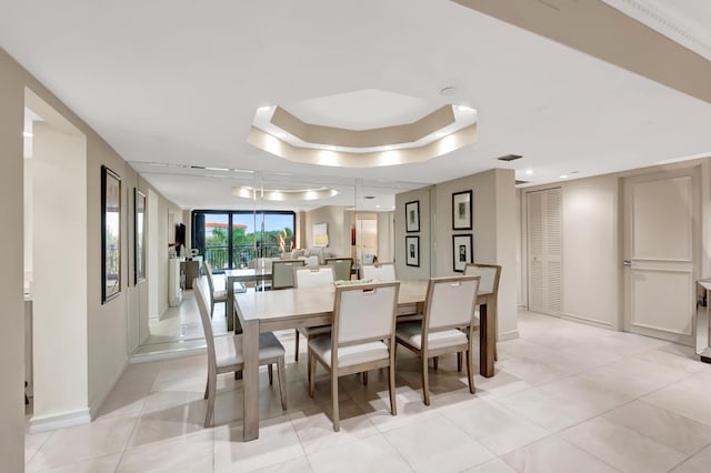 tiled dining area featuring a wall of windows and a tray ceiling