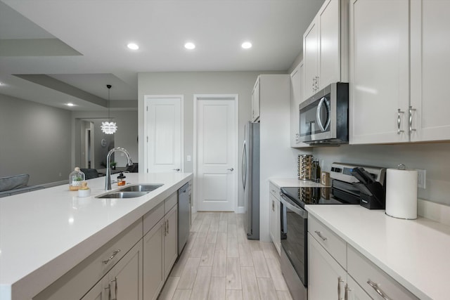 kitchen with sink, white cabinets, pendant lighting, and appliances with stainless steel finishes