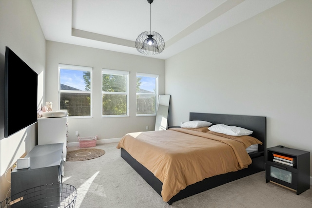 carpeted bedroom with a tray ceiling