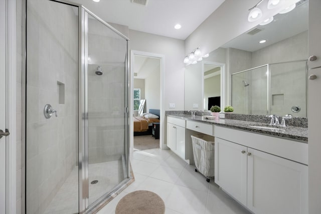 bathroom with a shower with door, tile patterned flooring, and vanity