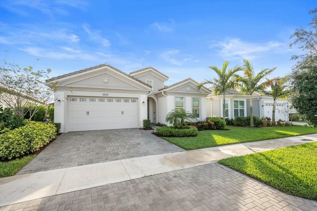 ranch-style house featuring a garage and a front lawn