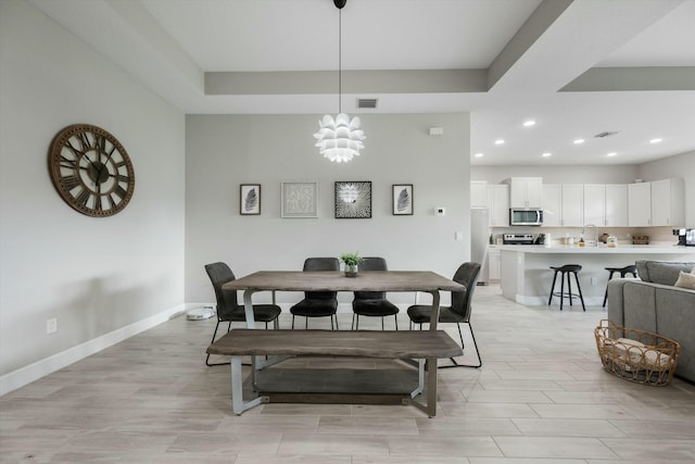 dining area with sink and a chandelier