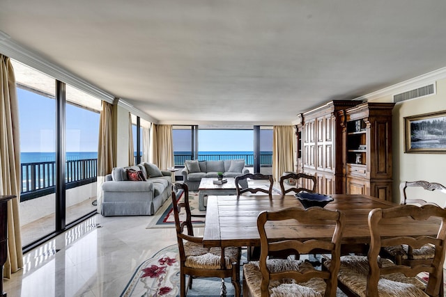 dining space with crown molding, a water view, and a healthy amount of sunlight