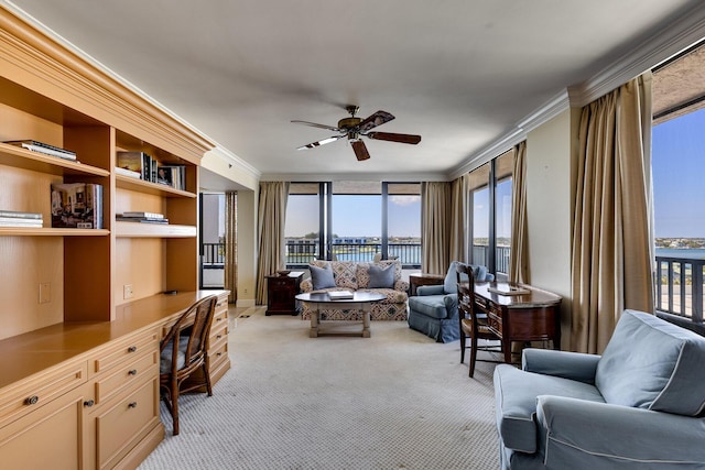 carpeted office with a water view, ceiling fan, ornamental molding, and built in desk