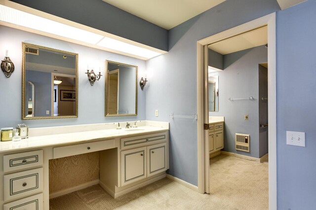 bathroom featuring heating unit and vanity