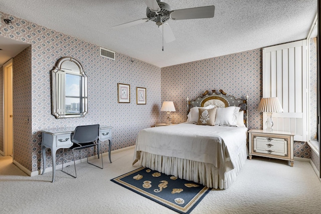 carpeted bedroom with ceiling fan and a textured ceiling