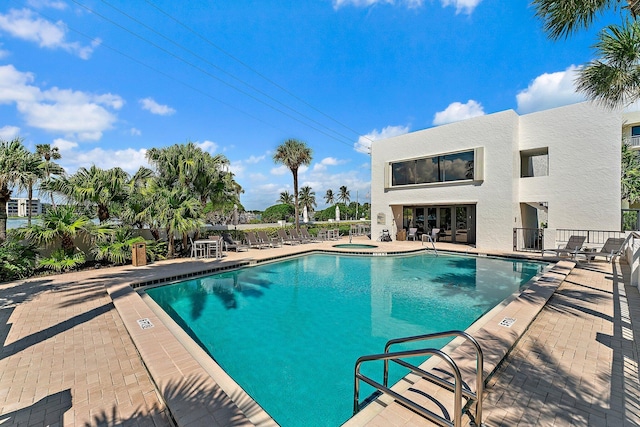 view of pool featuring a hot tub and a patio