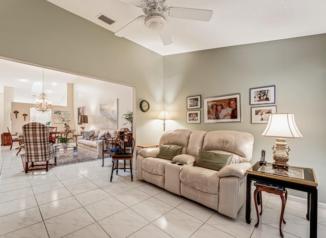 living room with ceiling fan with notable chandelier and a textured ceiling