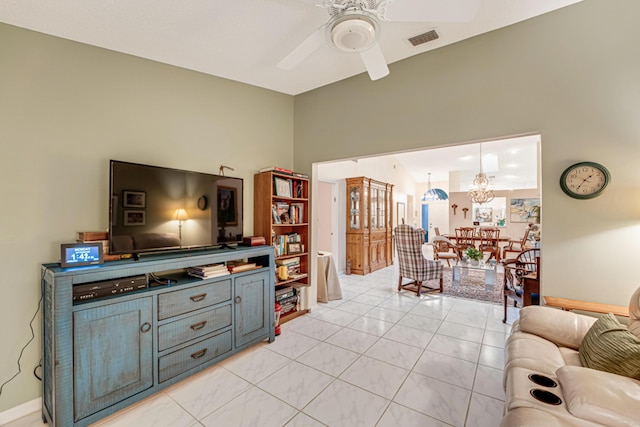 living room with ceiling fan with notable chandelier