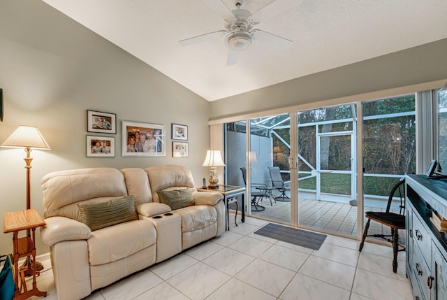 living room featuring a healthy amount of sunlight, light tile patterned floors, lofted ceiling, and ceiling fan