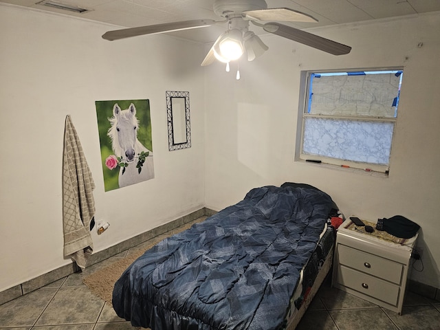 tiled bedroom featuring ceiling fan and crown molding