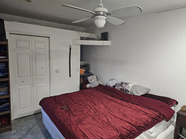 tiled bedroom featuring ceiling fan and a closet