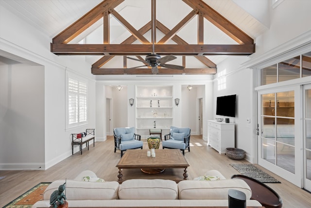 living room featuring beam ceiling, built in features, and light hardwood / wood-style floors