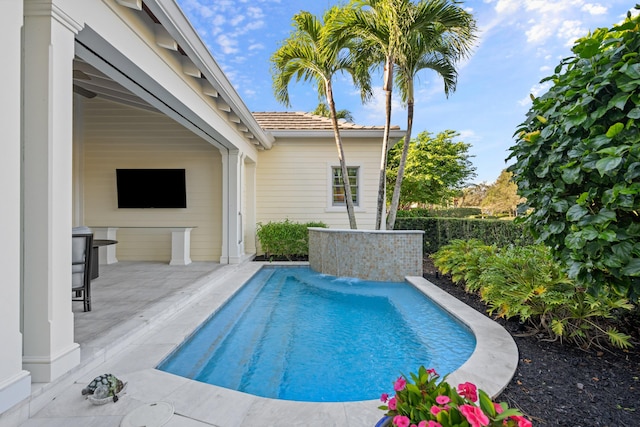 view of swimming pool with pool water feature and a patio area