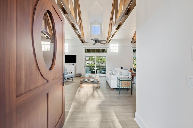 interior space with light wood-type flooring and beam ceiling