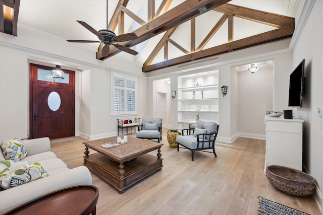 living room featuring light hardwood / wood-style flooring, ceiling fan, high vaulted ceiling, built in shelves, and beamed ceiling