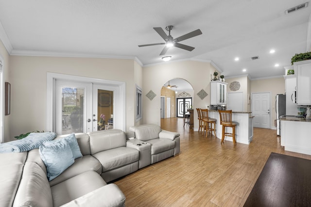 living room with lofted ceiling, light hardwood / wood-style floors, french doors, and ceiling fan