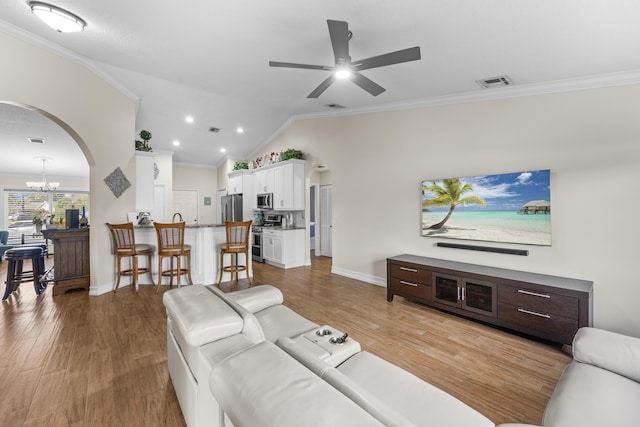 living room featuring crown molding, lofted ceiling, ceiling fan with notable chandelier, and light hardwood / wood-style flooring