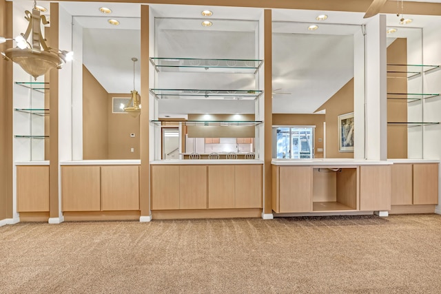 kitchen with light colored carpet, light brown cabinetry, and vaulted ceiling