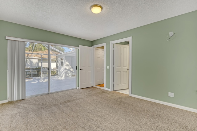 unfurnished room with light carpet and a textured ceiling